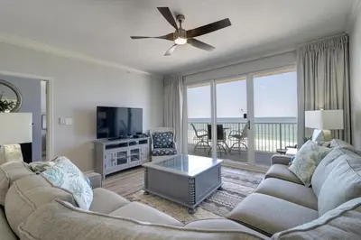 a living room with a couch and a tv at Gulf Front Master Suite! Directly On The Beach! 3 BR / 2 BA! Sleeps 8! in Panama City Beach