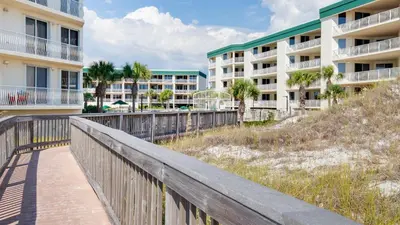 a boardwalk in front of two apartment buildings at Stunning 2 BR/2 BA Third Floor Unit Directly On Santa Rosa Beach! Sleeps 6! in Santa Rosa Beach