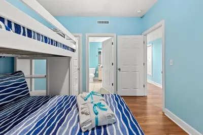 a bedroom with blue walls and a bunk bed at Large Balcony! Gulf Front Master Suite! Many Amenities On-Site! in Panama City Beach