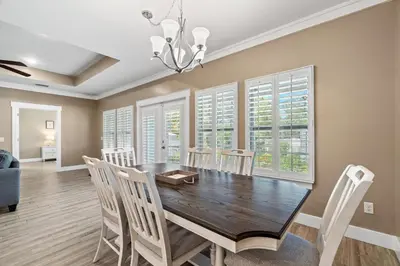 a dining room with a wooden table and chairs at Charming Retreat, a Short Walk to Laguna Beach, with Room for 10! in Panama City Beach