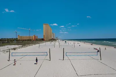 a group of people playing volleyball on a beach at Charming Retreat, a Short Walk to Laguna Beach, with Room for 10! in Panama City Beach