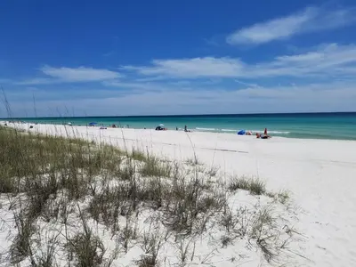 a beach with a lot of people on the beach at Spacious Waterfront Townhome - Just A Short Walk to Pier Park in Panama City Beach
