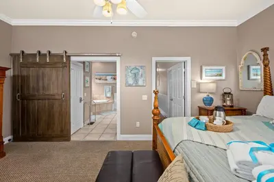 a bedroom with a bed and a couch at Algun Dia - Plush Family-Friendly Home - A Block from Beach in Panama City Beach