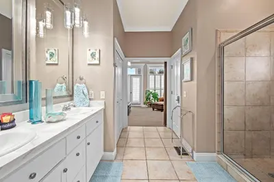 a bathroom with two sinks and a shower at Algun Dia - Plush Family-Friendly Home - A Block from Beach in Panama City Beach