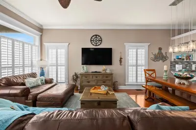 a living room with a couch and a tv at Algun Dia - Plush Family-Friendly Home - A Block from Beach in Panama City Beach