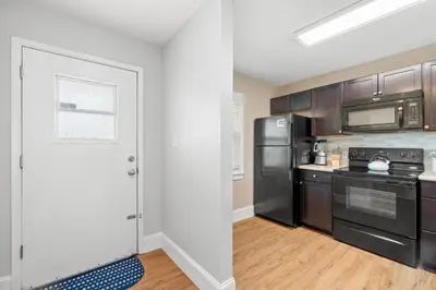 a kitchen with stainless steel appliances and wooden cabinets at 120 Palm Beach Dr A - La Casa Turquesa in Panama City Beach