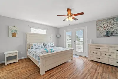 a bedroom with a bed and a ceiling fan at 120 Palm Beach Dr A - La Casa Turquesa in Panama City Beach