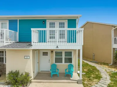 a house with two blue chairs in front of it at 120 Palm Beach Dr A - La Casa Turquesa in Panama City Beach