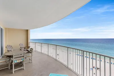 a balcony with a table and chairs and the ocean at NEW PROPERTY! Vacation Right on the Gulf in Sand & Seafoam Villa Sleeps 6! in Panama City Beach