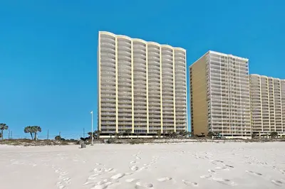 two tall buildings on the beach with footprints in the sand at NEW PROPERTY! Vacation Right on the Gulf in Sand & Seafoam Villa Sleeps 6! in Panama City Beach