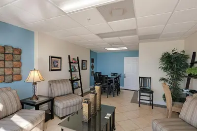a living room with couches and a dining room at NEW PROPERTY! Vacation Right on the Gulf in Sand & Seafoam Villa Sleeps 6! in Panama City Beach