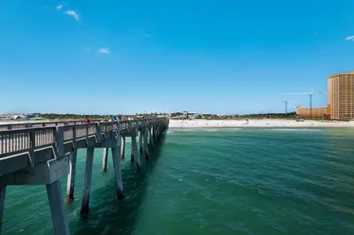 a pier over the ocean with a beach in the background at Sleep in Comfort in The Most Spacious 2 Bedrooms Tidewater Has to Offer in Panama City Beach