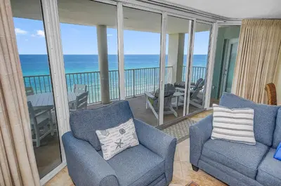 a living room with two chairs and a balcony with the ocean at Beautiful Long Beach Condo unit 1-1206! TWO Gulf Masters! in Panama City Beach