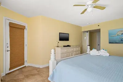 a bedroom with a bed with a ceiling fan and a television at Beautiful Long Beach Condo unit 1-1206! TWO Gulf Masters! in Panama City Beach