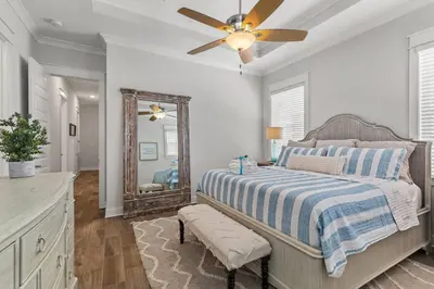 a bedroom with a bed with a ceiling fan and a mirror at 24 York Lane | Edgewater Escape in Inlet Beach