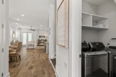 a kitchen and living room with white walls and wooden floors at 24 York Lane | Edgewater Escape in Inlet Beach