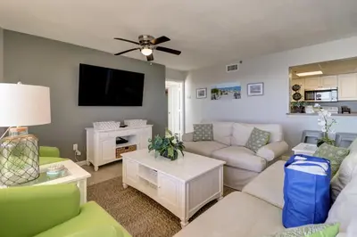 a living room with a couch and a tv at Amazing Views! Newly Listed! Family Friendly Unit! Resort Pools! in Panama City Beach