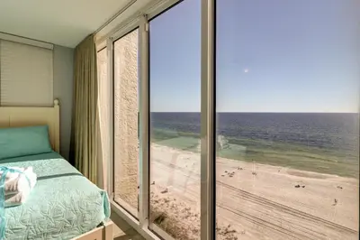 a bedroom with a bed and a view of the beach at Amazing Views! Newly Listed! Family Friendly Unit! Resort Pools! in Panama City Beach