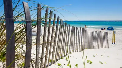 a fence on the beach with the ocean in the background at Great Rates Available NOW! / Relaxing Coastal Beach Home West PCB / 3Bd & 2Ba in Panama City Beach