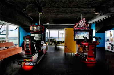 a room with two arcade games and a couch at Gulf Front! 2 BR 2 BA! 11th Floor condo + Condo Amenities! in Panama City Beach