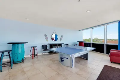a room with a ping pong table and chairs at Gulf Front! 2 BR 2 BA! 11th Floor condo + Condo Amenities! in Panama City Beach