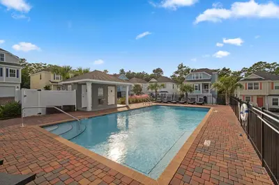 a swimming pool in the middle of a house at The FUN Orange home in a Great Location with bonus GAME room in Rosemary Beach