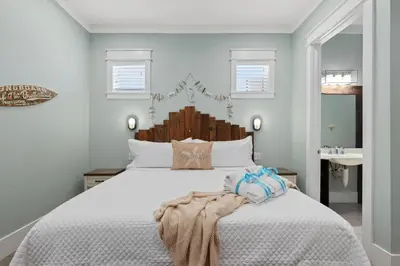 a bedroom with a white bed with a wooden headboard at Three Master Bedrooms! Easy Beach Access! Gulf Views in Panama City Beach