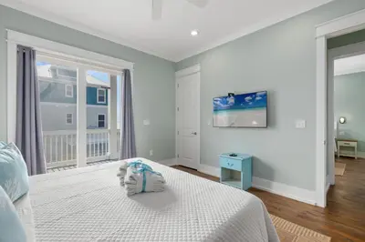 a white bedroom with a bed and a window at Three Master Bedrooms! Easy Beach Access! Gulf Views in Panama City Beach