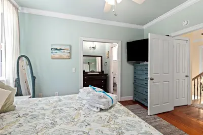 a bedroom with a bed and a dresser and a television at 109 Island Cove Ct - Blue Palm Cove in Panama City Beach