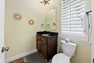 a bathroom with a toilet and a sink and a mirror at 109 Island Cove Ct - Blue Palm Cove in Panama City Beach