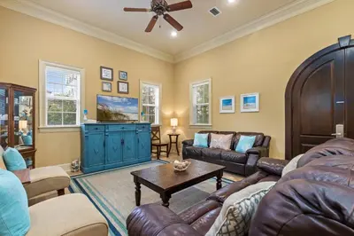 a living room with leather furniture and a ceiling fan at Luxury Home in Palmeira Village w Private Pool, Steps to Beach for 12! in Santa Rosa Beach