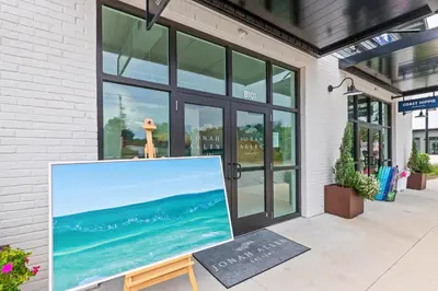 a painting on a easel outside of a building at Luxury Home in Palmeira Village w Private Pool, Steps to Beach for 12! in Santa Rosa Beach