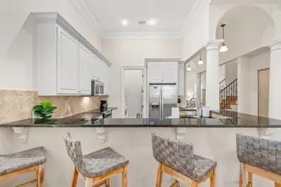 a kitchen with white cabinets and bar stools at Feel Like Luxury Vacationing in this Private Community in Seagrove on 30A in Santa Rosa Beach