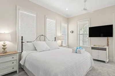 a white bedroom with a bed and a flat screen tv at Feel Like Luxury Vacationing in this Private Community in Seagrove on 30A in Santa Rosa Beach