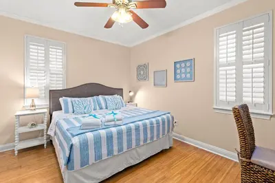 a bedroom with a bed and a ceiling fan at Expertly Decorated Family Home, Steps to Beach w/ a Private Heated Pool & Spa! in Panama City Beach