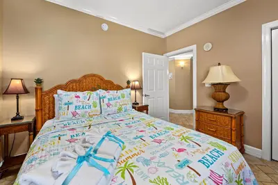 a bedroom with a bed with a blue bow on it at Gulf Front Master Bedroom, 2 Pools & Hot Tubs, Sleeps 8 in Panama City Beach