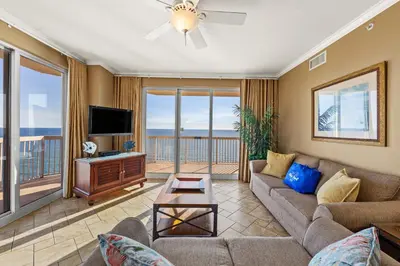 a living room with a couch and a tv at Gulf Front Master Bedroom, 2 Pools & Hot Tubs, Sleeps 8 in Panama City Beach