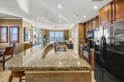 a kitchen with a large island in the middle at Gulf Front Master Bedroom, 2 Pools & Hot Tubs, Sleeps 8 in Panama City Beach