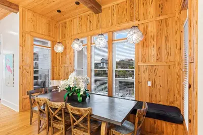 a dining room with wooden walls and a table and chairs at 12 Periwinkle Ln - Beach Blessings in Santa Rosa Beach