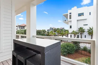 a balcony with a table and a view of a building at 12 Periwinkle Ln - Beach Blessings in Santa Rosa Beach
