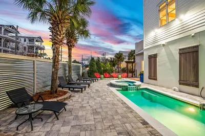 a backyard with a swimming pool and palm trees at 12 Periwinkle Ln - Beach Blessings in Santa Rosa Beach