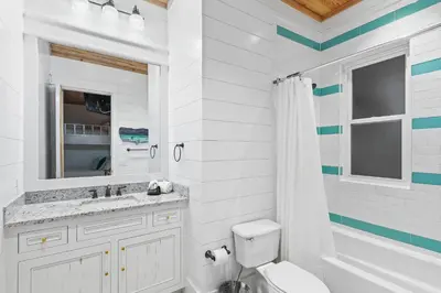 a white bathroom with a toilet and a sink at 12 Periwinkle Ln - Beach Blessings in Santa Rosa Beach