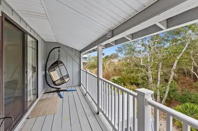 an empty porch with a swing on it at Short Walk to The Beach! Community Pool! Sleeps 6! in Panama City Beach