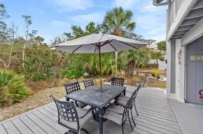 a table and chairs with an umbrella on a deck at Short Walk to The Beach! Community Pool! Sleeps 6! in Panama City Beach