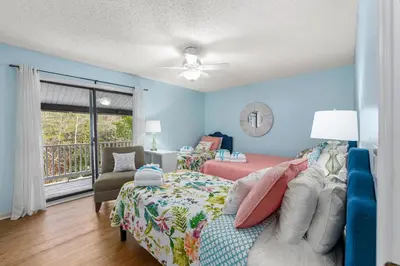 a bedroom with blue walls and a bed and a couch at Short Walk to The Beach! Community Pool! Sleeps 6! in Panama City Beach