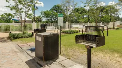 a park with two trash cans and a fence at Laketown Wharf 911 - Luxury at the Wharf in Panama City Beach
