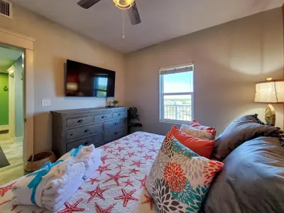 a bedroom with a bed and a dresser and a television at Laketown Wharf 911 - Luxury at the Wharf in Panama City Beach