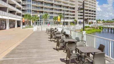 a boardwalk with tables and chairs in front of a building at Laketown Wharf 911 - Luxury at the Wharf in Panama City Beach