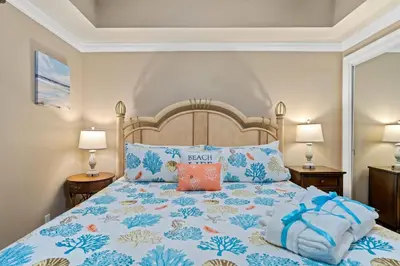 a bedroom with a bed with a blue and white bedspread at Right Across The Street From Pier Park! 2 Pools Overlooking Gulf!Next To Pier in Panama City Beach