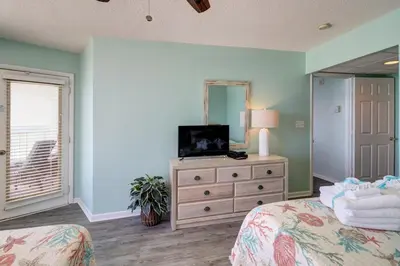 a bedroom with a bed and a dresser with a mirror at The Perfect Escape! Long Beach Resort-8th Floor-Gulf Front with AMAZING views in Panama City Beach